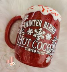 a red coffee mug with white frosting on it and the words winter blend hot cocoa served daily