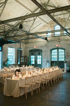 a long table is set up in an old warehouse