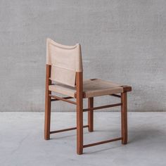 a wooden chair sitting on top of a cement floor