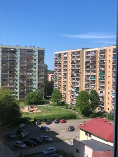 an apartment complex with cars parked in the parking lot and several buildings on either side