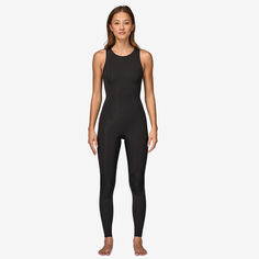 a woman wearing a black wetsuit and standing in front of a white background