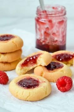 raspberry jam cookies with fresh raspberries on the side and jar of jelly