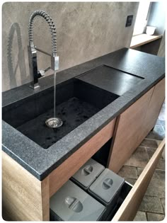 a kitchen sink under a faucet with soap dispensers in it