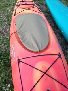 two kayaks sitting on the grass next to each other