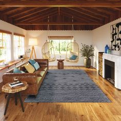 a living room filled with furniture and a fire place next to a wooden floored wall