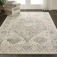 a white rug with an ornate design on the floor in front of a door and window