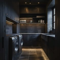 a washer and dryer in a very dark looking room with tile flooring