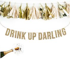 a party banner that says drink up daring with champagne and streamers in the background