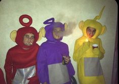 three people in costumes are standing next to each other and one is holding a lit candle