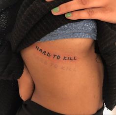 a woman's stomach with the words, hard to kill written on her side