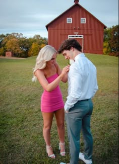 a woman in a pink dress standing next to a man