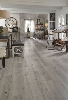 a living room filled with furniture and a wooden floor covered in hard wood planks