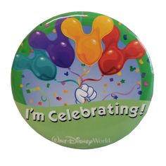 a button with mickey mouse balloons and the words i'm celebrating on it in front of a white background