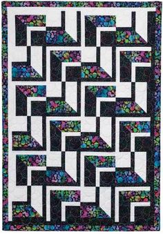 a black and white quilt with multicolored squares on the front, along with an interlaced design