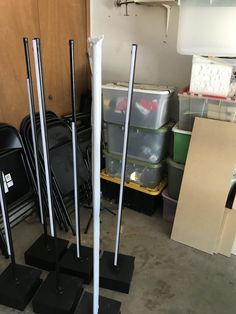 several black and white poles in a room with many boxes on the floor next to them