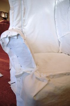 an upholstered white chair with holes in the fabric