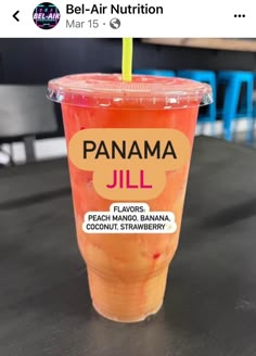 a plastic cup filled with orange juice on top of a table