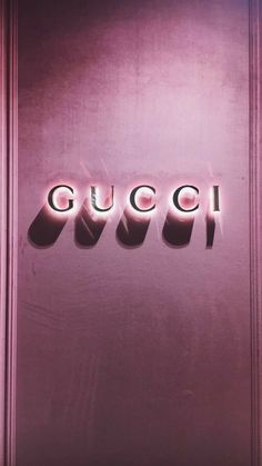 the word gucci is lit up in front of a purple wall