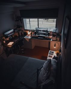 a bedroom with a bed, desk and computer