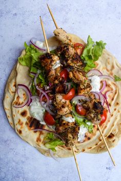 chicken and vegetable skewers on pita bread