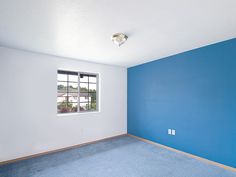 an empty room with blue walls and carpet