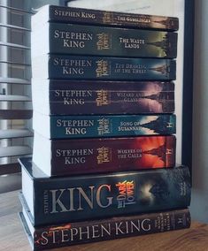 a stack of books sitting on top of a wooden table