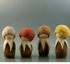 three wooden dolls with different colored hats on their heads