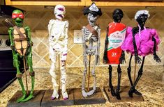 three halloween skeletons are standing in the kitchen