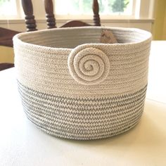 a basket sitting on top of a table next to a chair with a window in the background