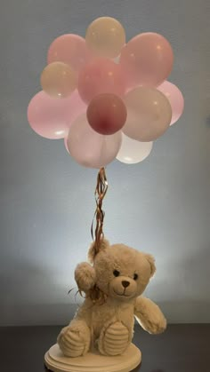 a teddy bear holding onto some balloons