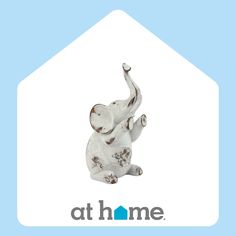 an elephant figurine sitting on top of a blue and white house with the words at home above it