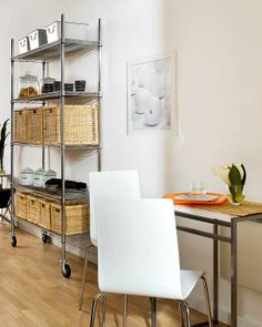 a dining room table and chairs with baskets on the top shelf in front of it