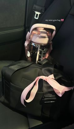 the back seat of a car with a bag on it's side and a pink ribbon