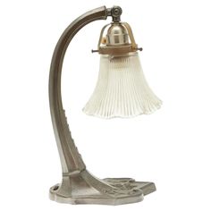 an antique desk lamp with a glass shade on the top and bottom part of it