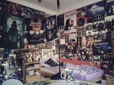 a bed room with a neatly made bed and lots of posters on the wall