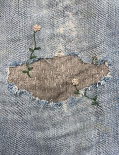 an old pair of jeans with holes and flowers on the side, as if they were torn apart