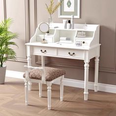 a white vanity with mirror and stool in a room next to a potted plant