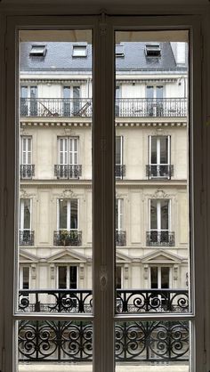 an open window in front of a building with balconies