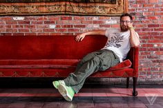 a man sitting on top of a red couch