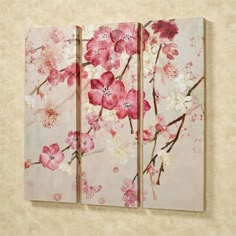 three panels with flowers painted on them in pink and white colors, hanging on the wall