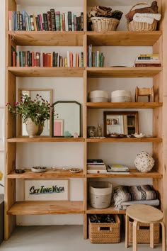 a bookshelf filled with lots of books and baskets