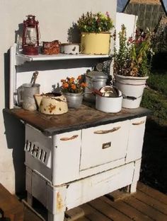 an old fashioned stove with pots and pans on it's burners outside