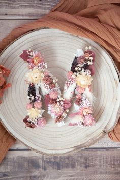 the letter m is made out of flowers on a white platter next to a brown cloth