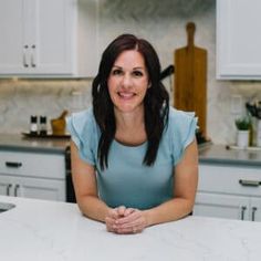 a woman sitting at a counter in a kitchen