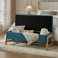 a bed with a blue upholstered headboard and foot board on top of it