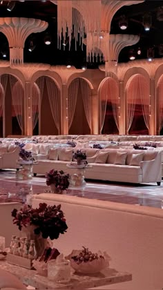 a room filled with white couches and chandeliers