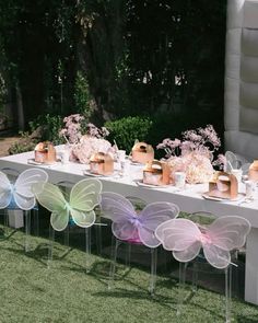 a long table covered in lots of different colored butterfly shaped chairs next to each other