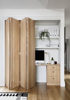 a room divider in the middle of a wooden floor with a computer on it