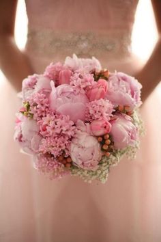 a bride holding a bouquet of pink flowers