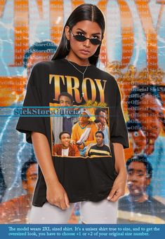 a woman wearing sunglasses and a t - shirt with the words troy on it